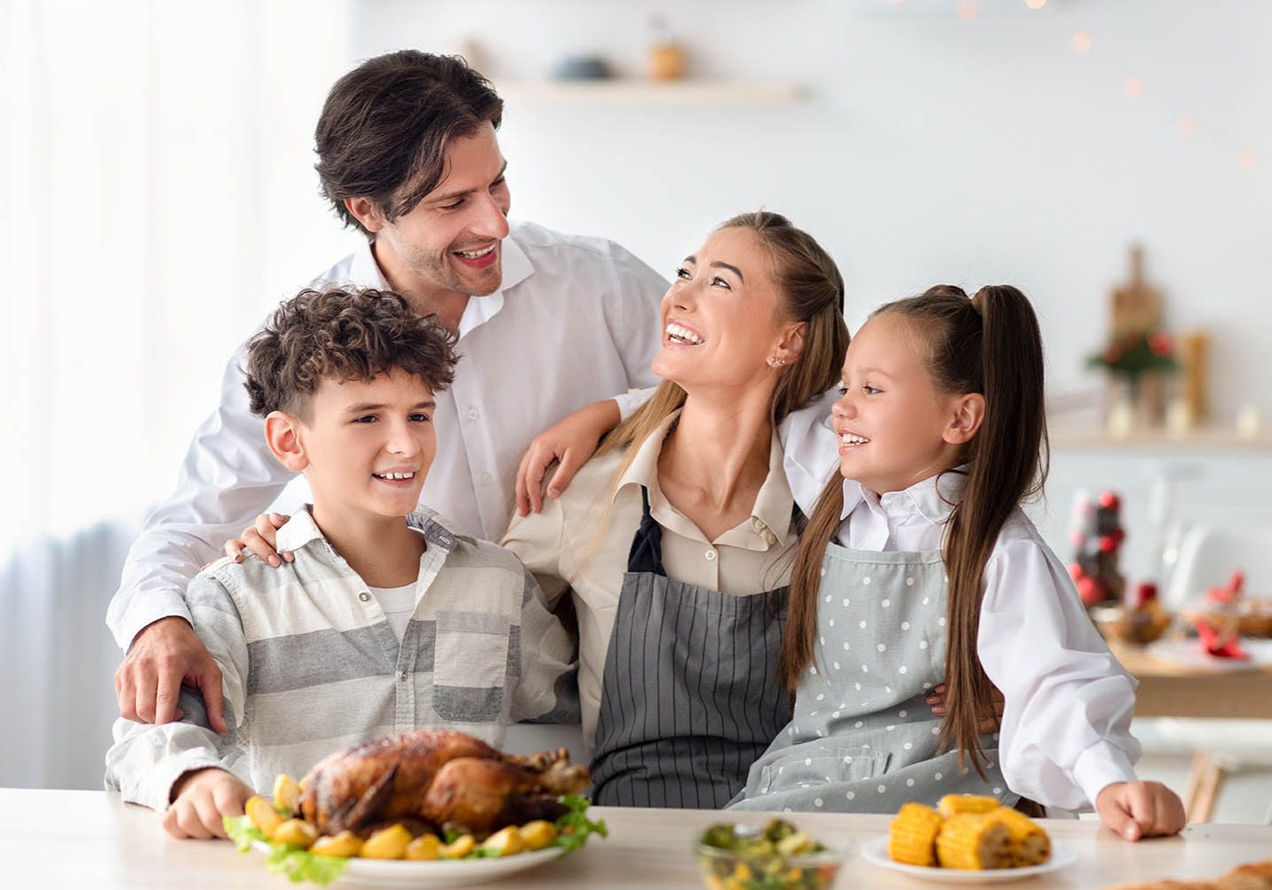 Portrait of happy family with parents and kids posing together in kitchen, preparing delicious meal for Christmas or Thanksgiving, cooking roasty turkey for festive dinner