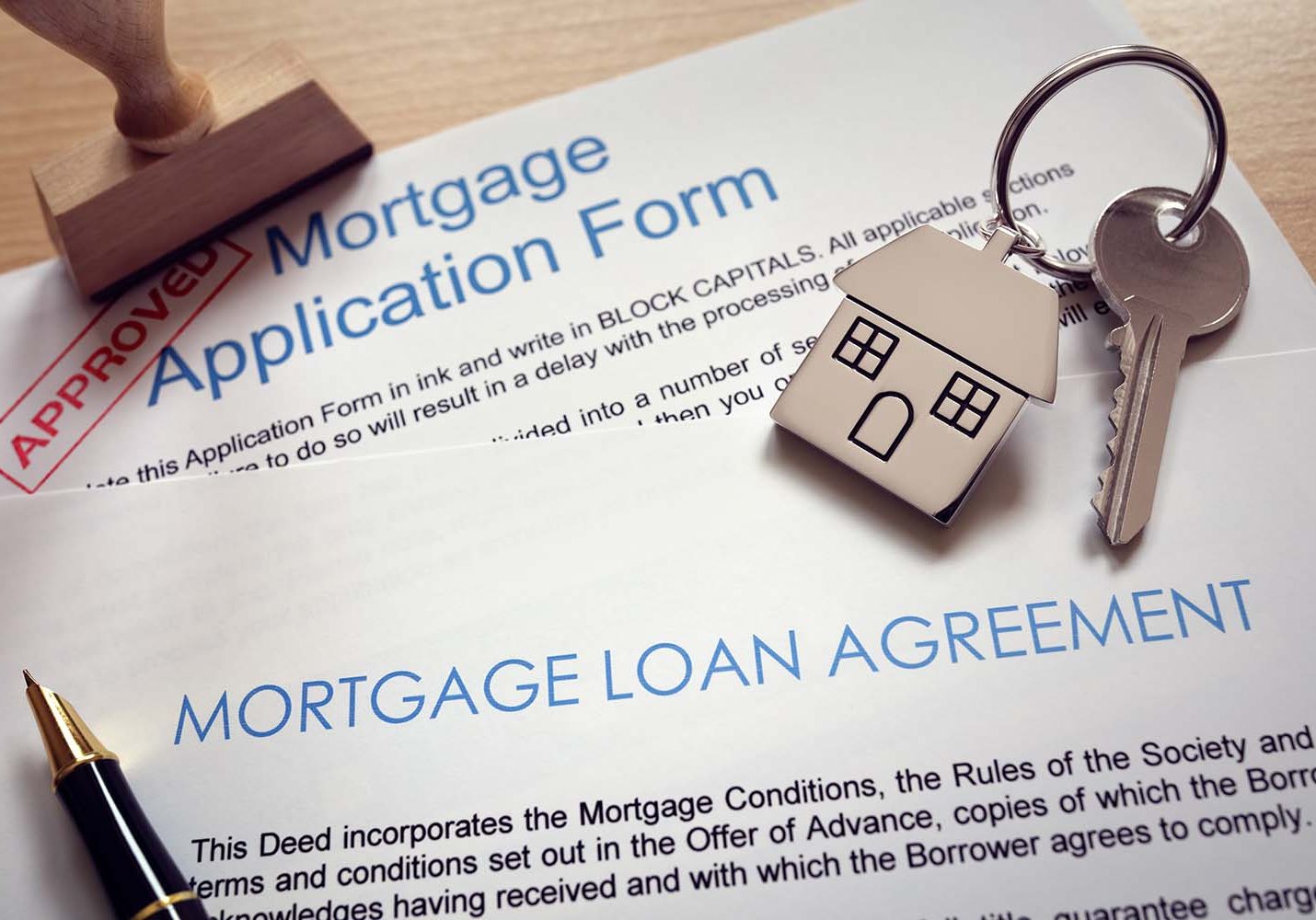 Mortgage loan agreement application with  key on house shaped keyring